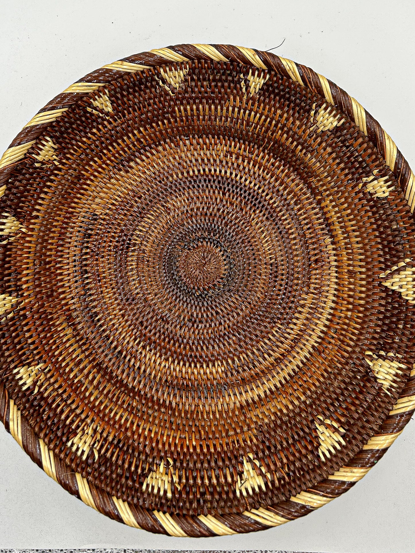 Brown & Cream Round Handwoven Basket from Papua New Guinea without handles with triangle and stripe detailing.