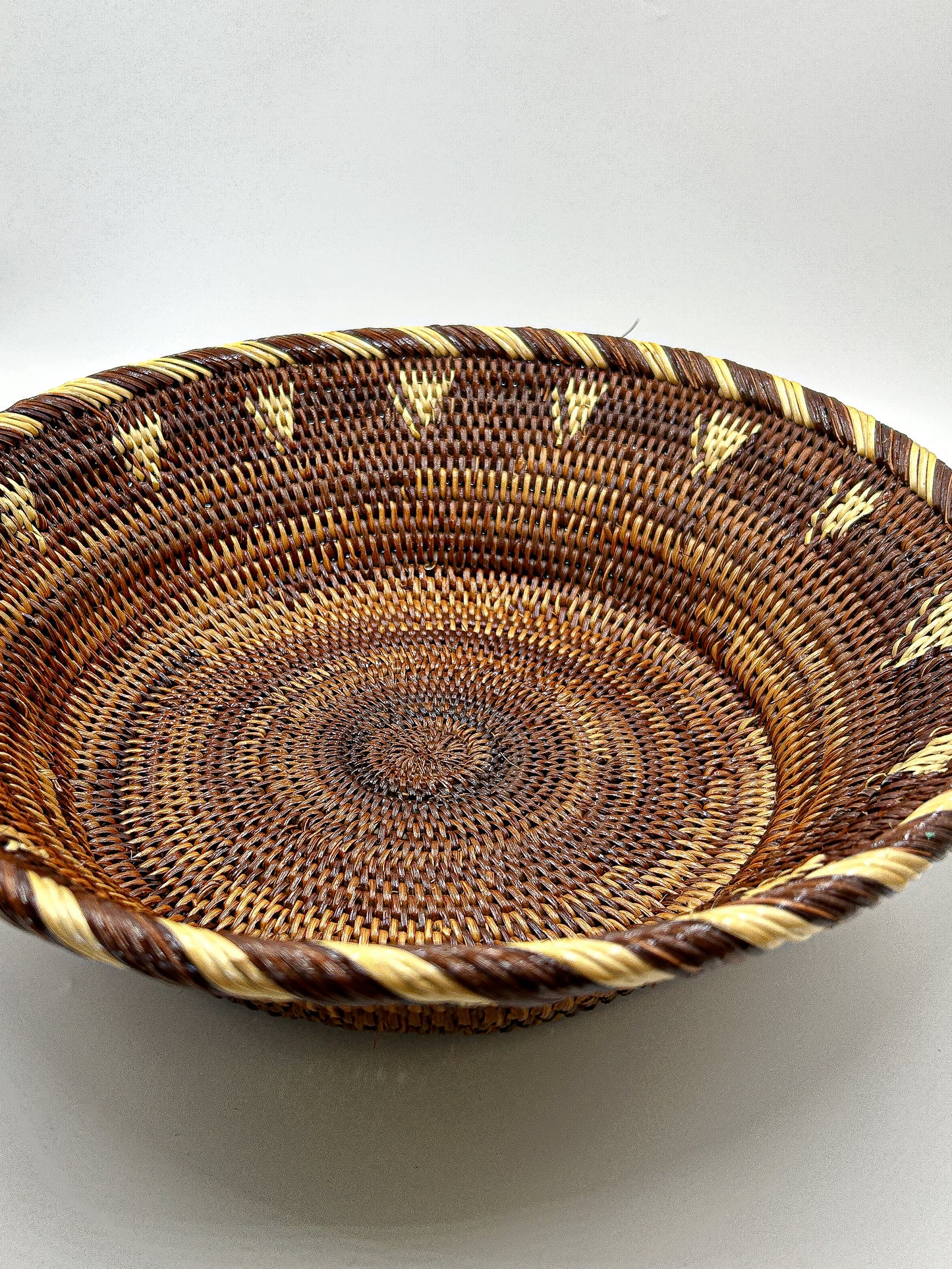 Brown & Cream Round Handwoven Basket from Papua New Guinea without handles with triangle and stripe detailing.