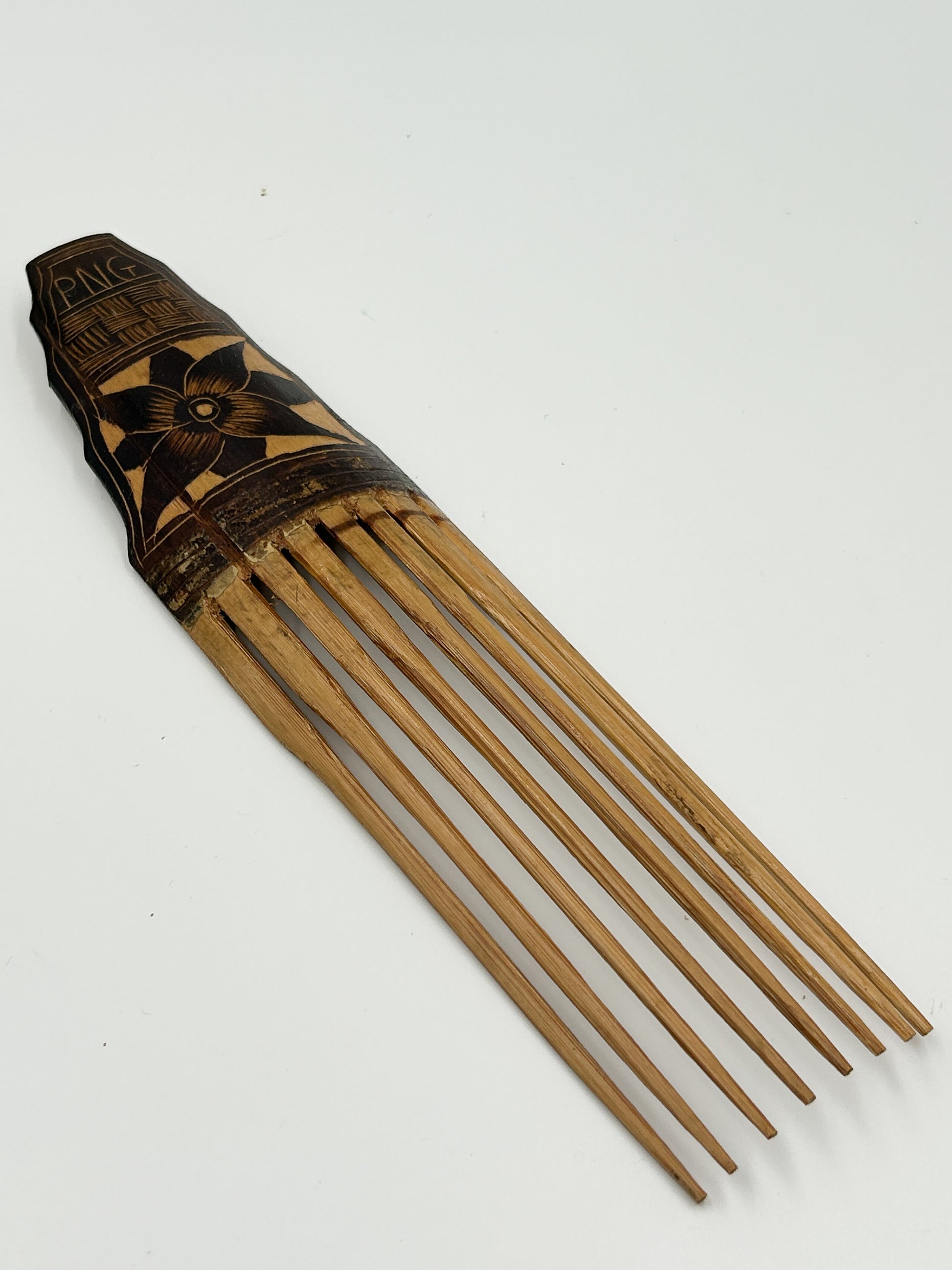 handcarved decorative hair comb from Papua New Guinea with flower detailing