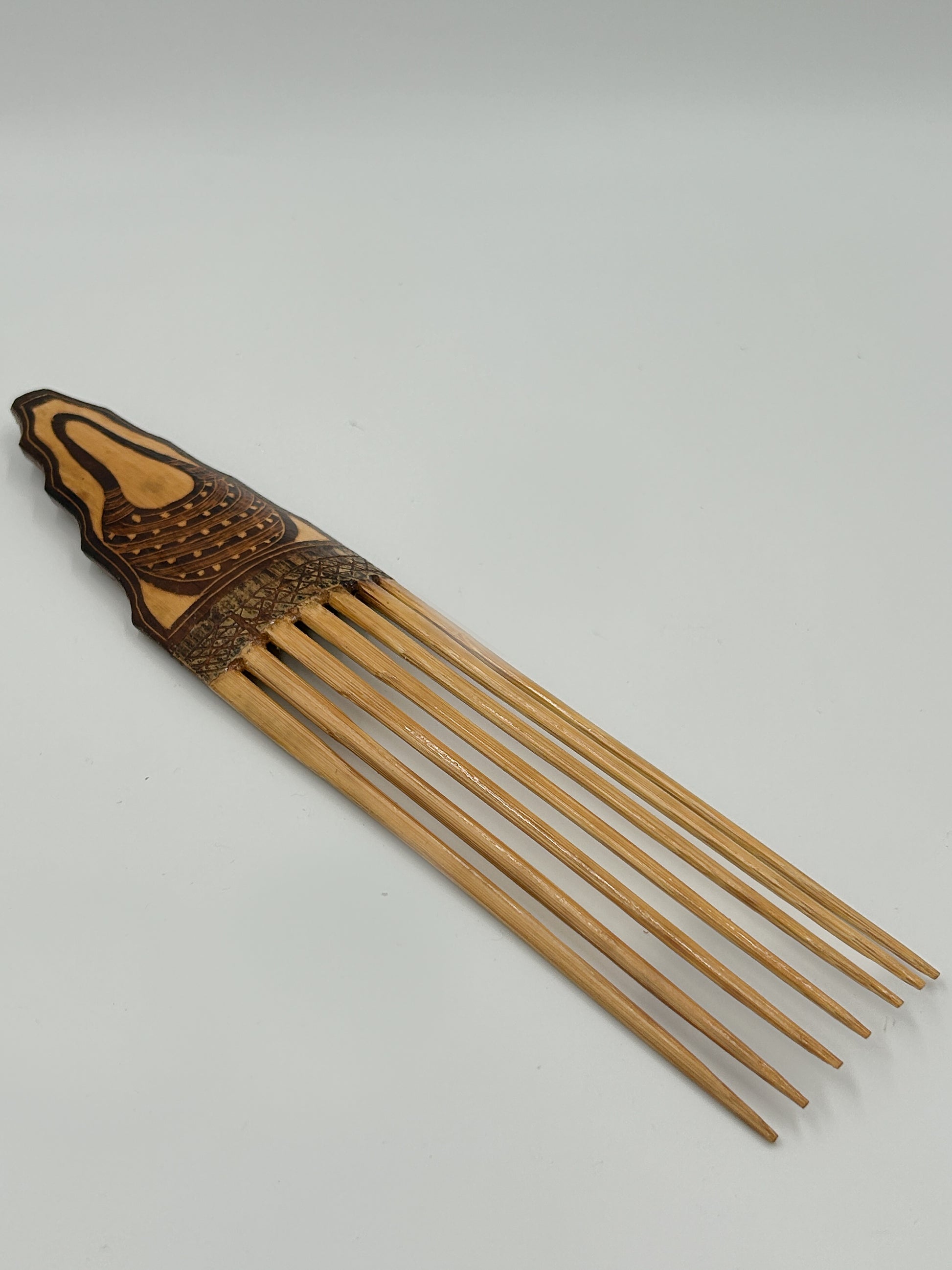 handcarved decorative hair comb from Papua New Guinea with Bilum Detailing